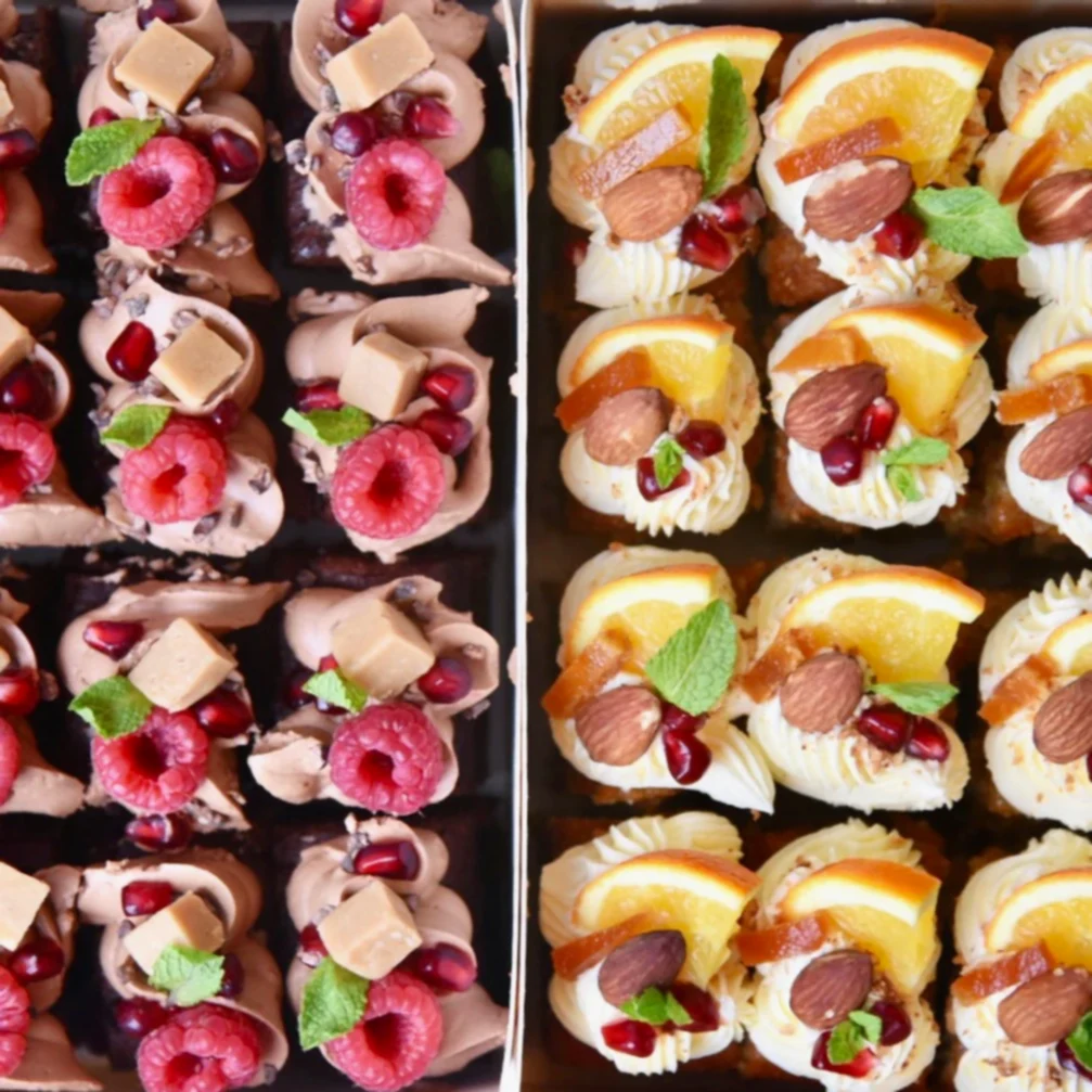 Cake bites boxed up and decorated with raspberries and oranges