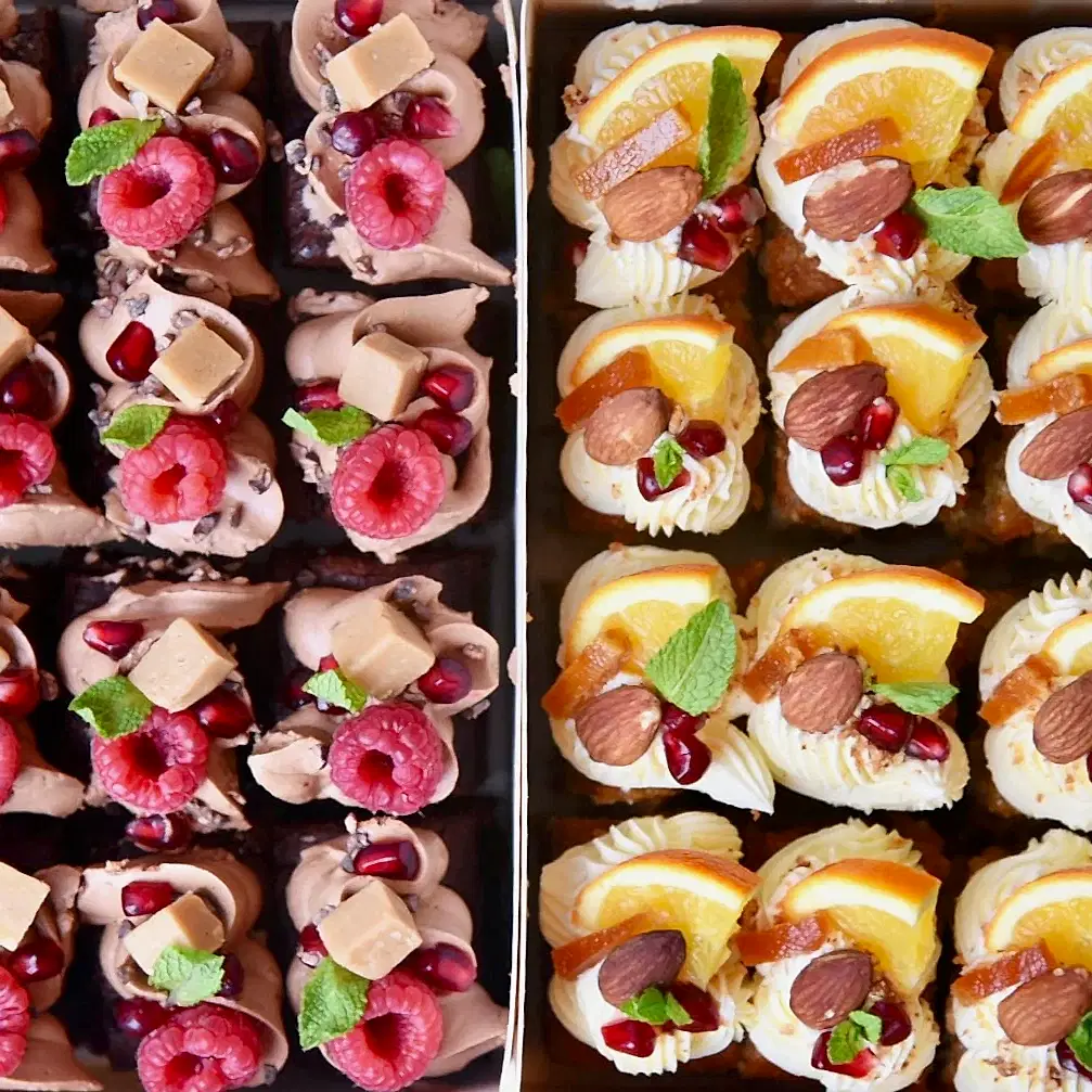 Cake bites boxed up and decorated with raspberries and oranges